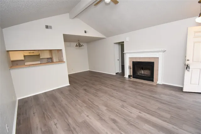 an empty room with wooden floor and a fireplace