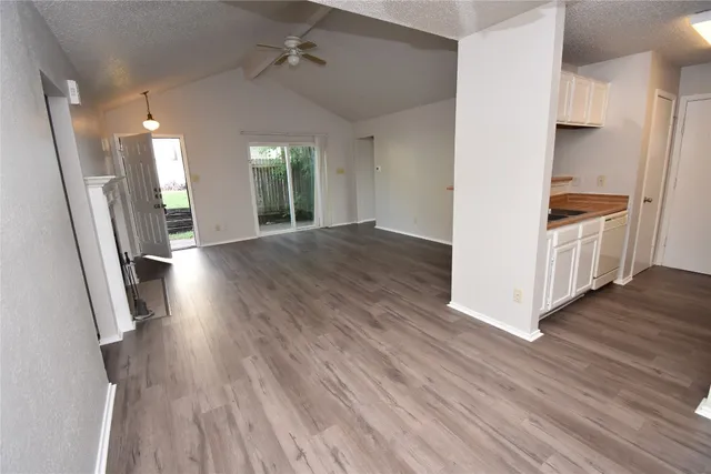a view of a kitchen with wooden floor and electronic appliances