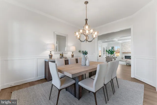 a living room with furniture large window and wooden floor