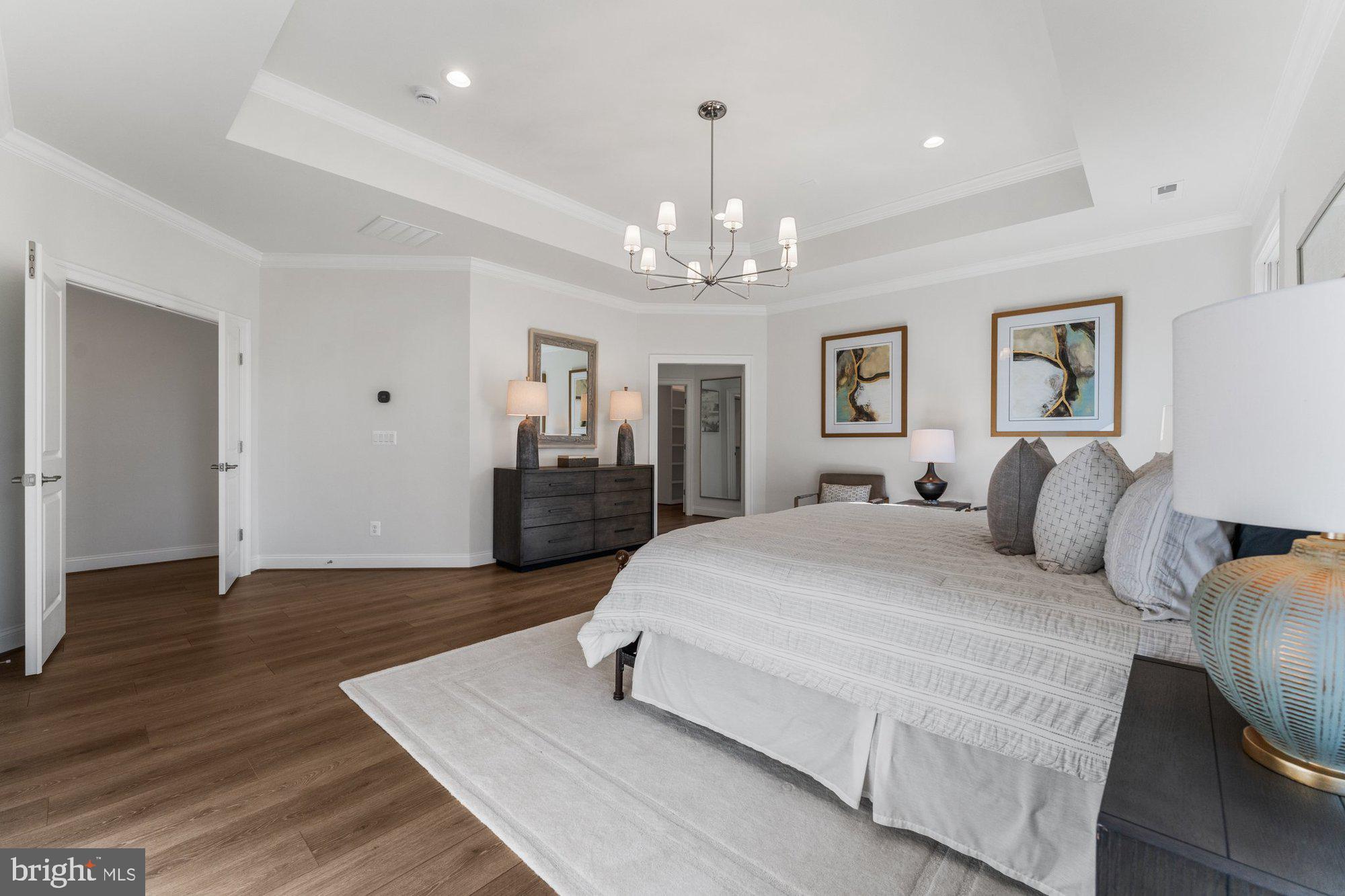 1767 Proffit Road Vienna, VA 22182 - Photo 54 of 117 a spacious bedroom with a large bed and a chandelier
