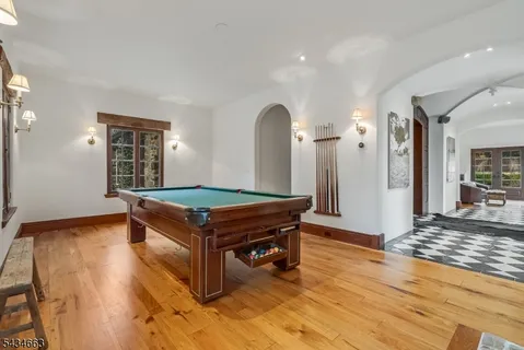 a room with pool table and wooden floor
