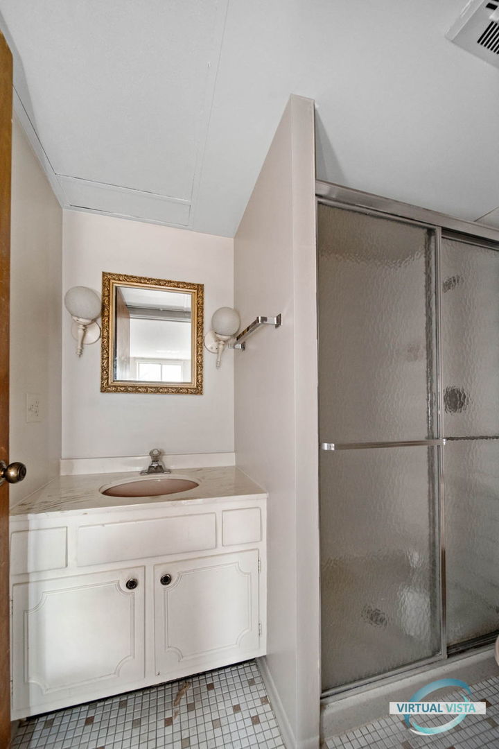 100 West Butterfield Road, Unit 210 Elmhurst, IL 60126 - Photo 10 of 27 a bathroom with a shower sink and mirror