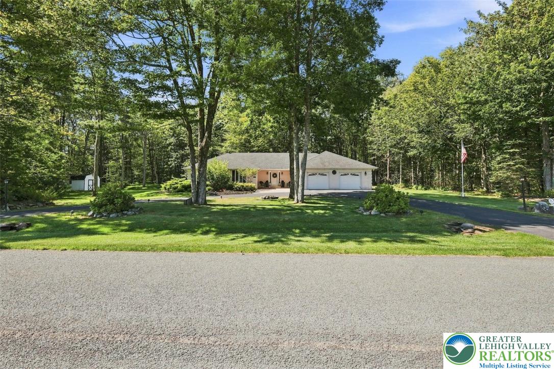 123 Meadow Road Blakeslee, PA 18610 - Photo 50 of 53 Mature trees frame the front lawn of this ranch-style home with an attached garage.