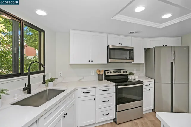 a kitchen with white cabinets and stainless steel appliances
