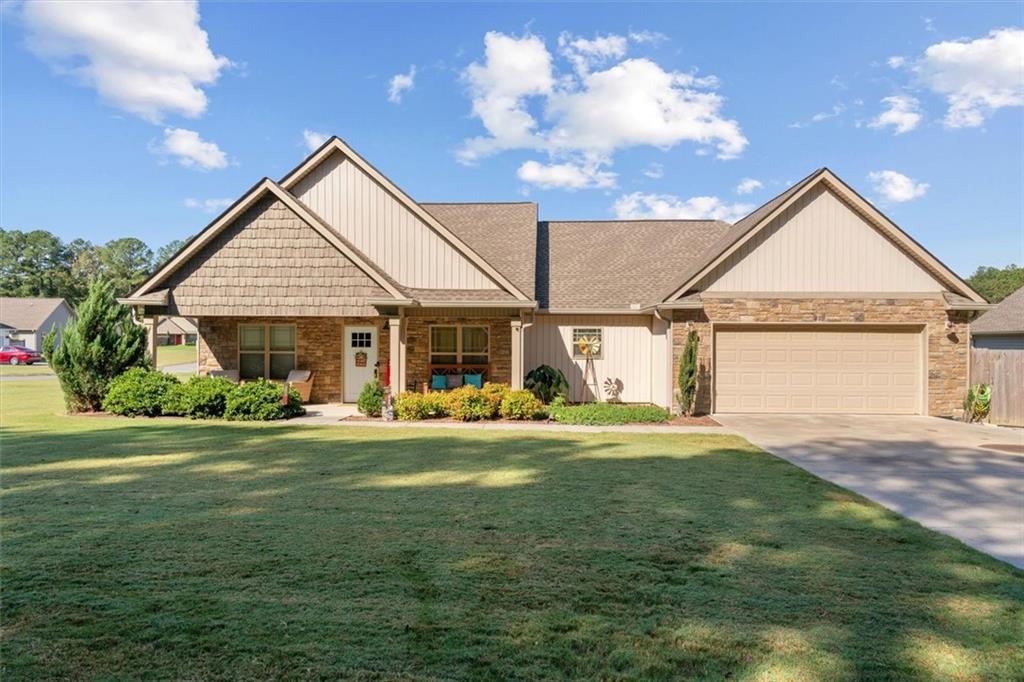 a front view of a house with a garden and trees