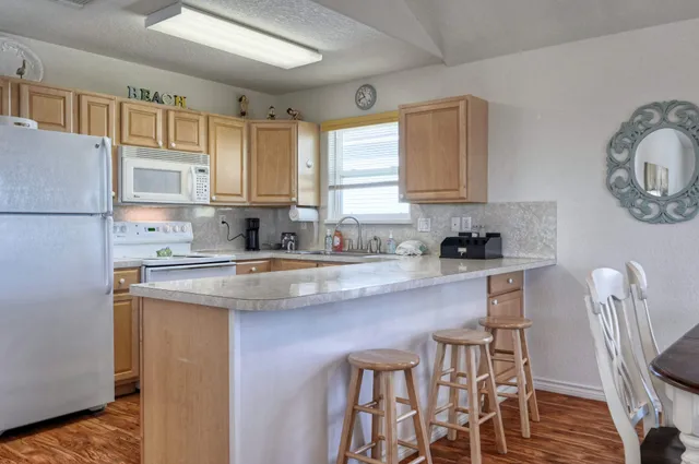 a kitchen with granite countertop white cabinets and white appliances