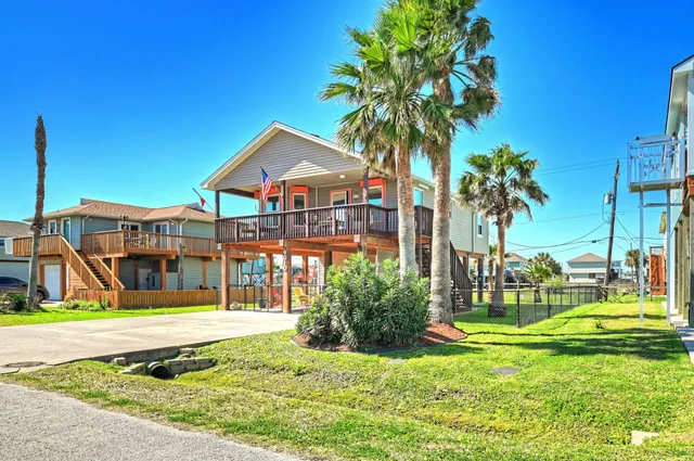 a view of swimming pool with lawn chairs and plants
