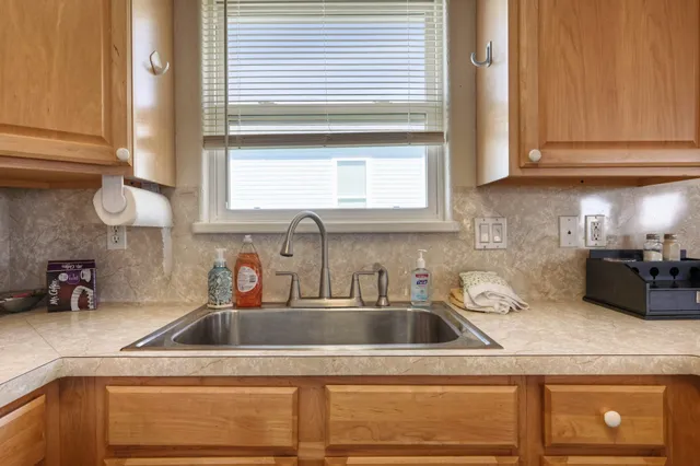 a living room with furniture a chandelier and wooden floor