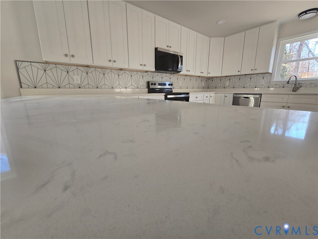 12084 Red Pine Road Ruther Glen, VA 22546 - Photo 14 of 49 Kitchen featuring white cabinets, light stone coun