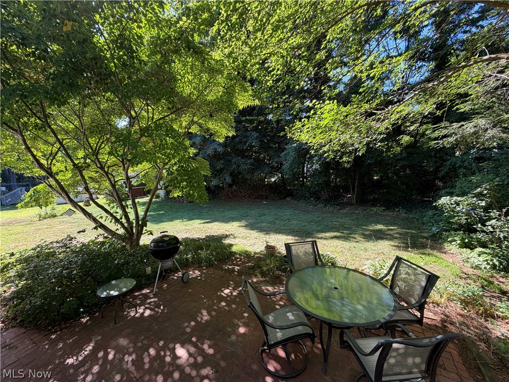 5770 Chapel Road Madison, OH 44057 - Photo 39 of 42 Expansive backyard featuring a brick paver patio, lush green lawn, and mature trees providing natural shading