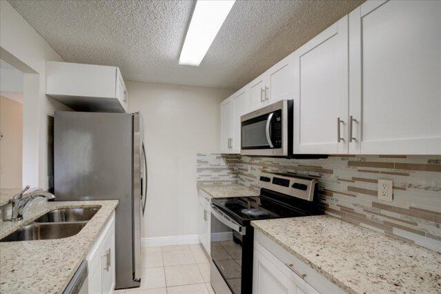 1104 Meadows Circle Boynton Beach, FL 33436 - Photo 13 of 27 a kitchen with a stove and a sink