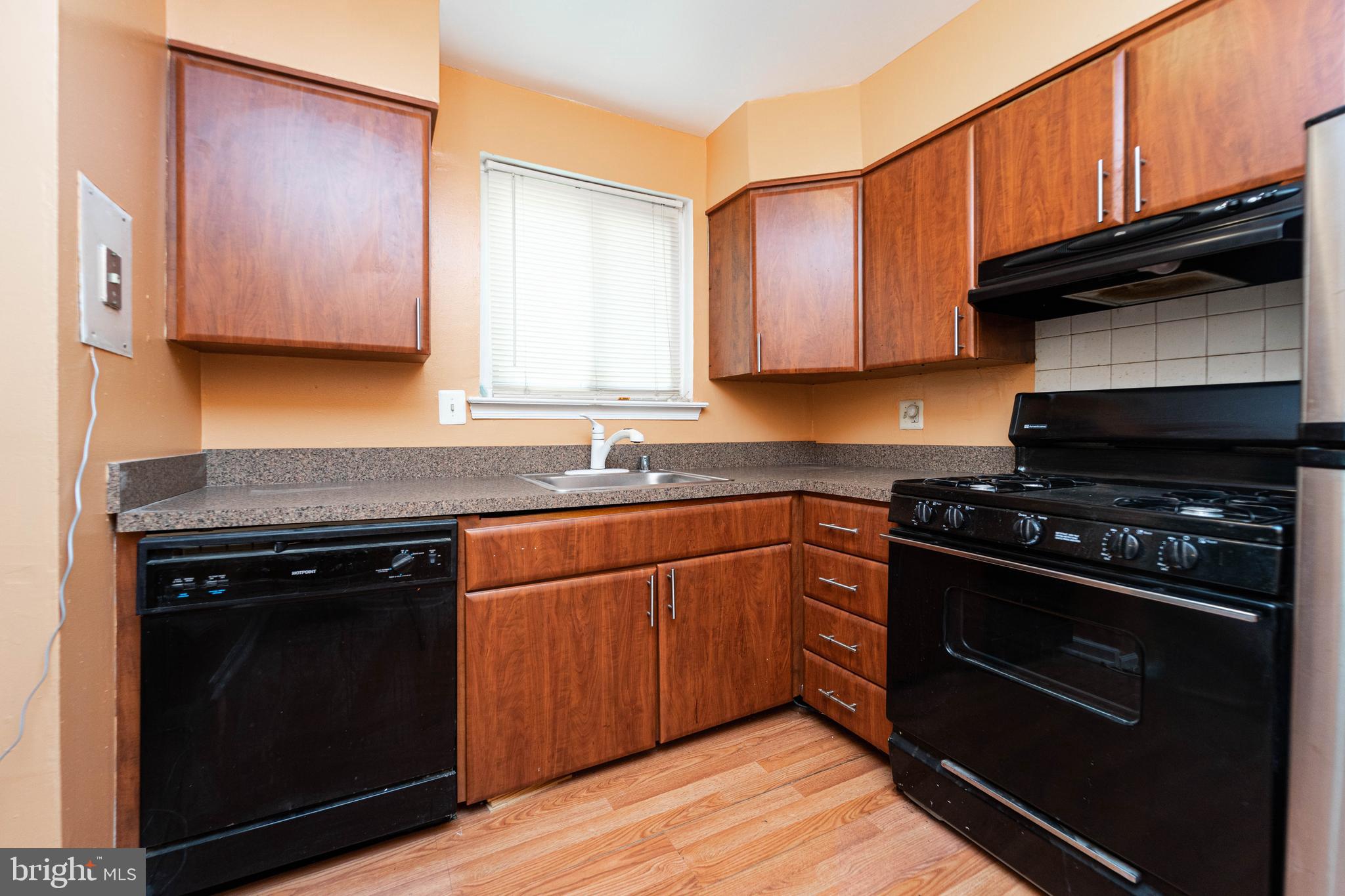 1923 Addison Road South District Heights, MD 20747 - Photo 14 of 30 a kitchen with stainless steel appliances granite countertop wooden cabinets stove top oven and sink