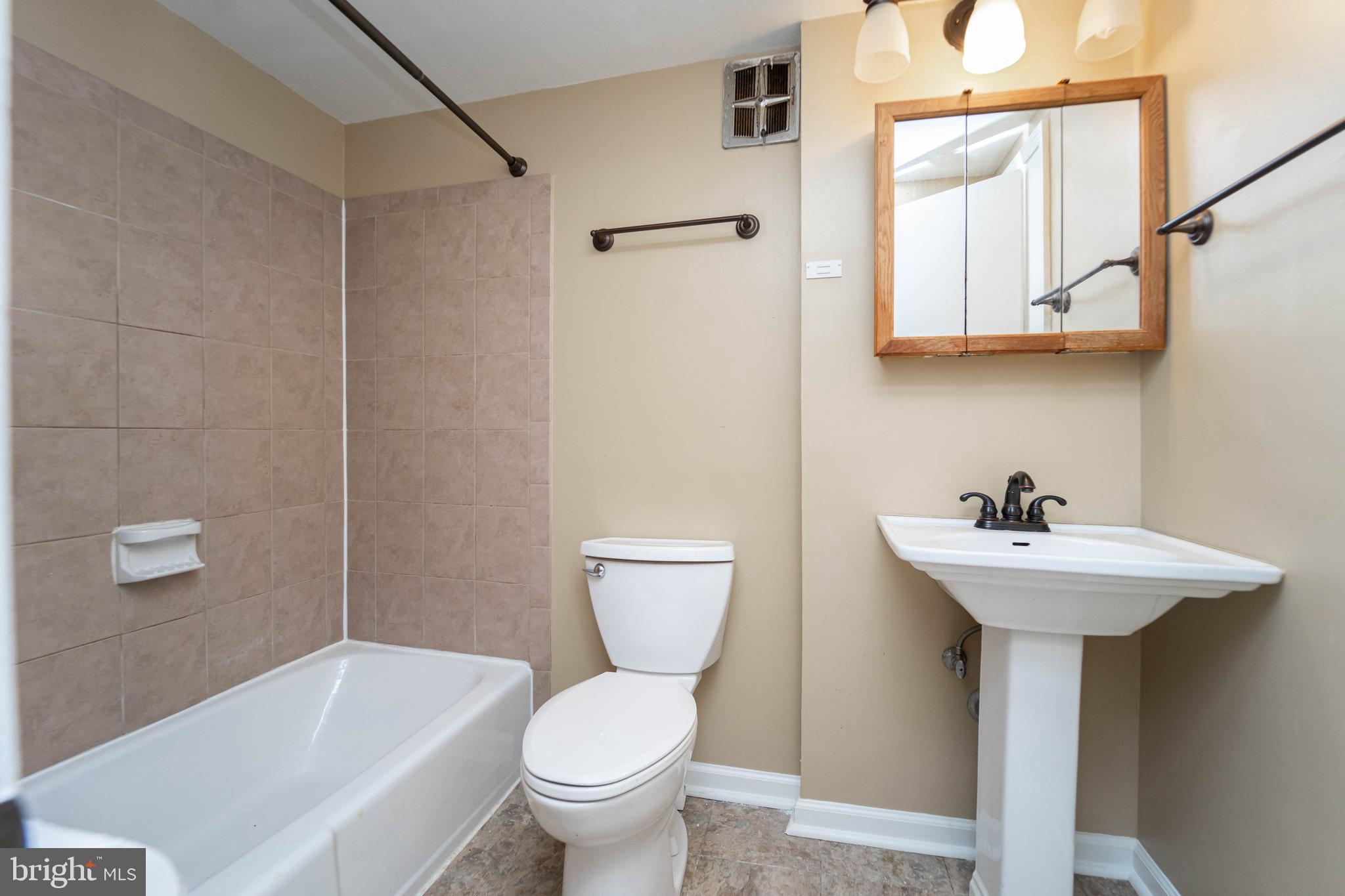 1923 Addison Road South District Heights, MD 20747 - Photo 22 of 30 a bathroom with a sink a toilet and shower
