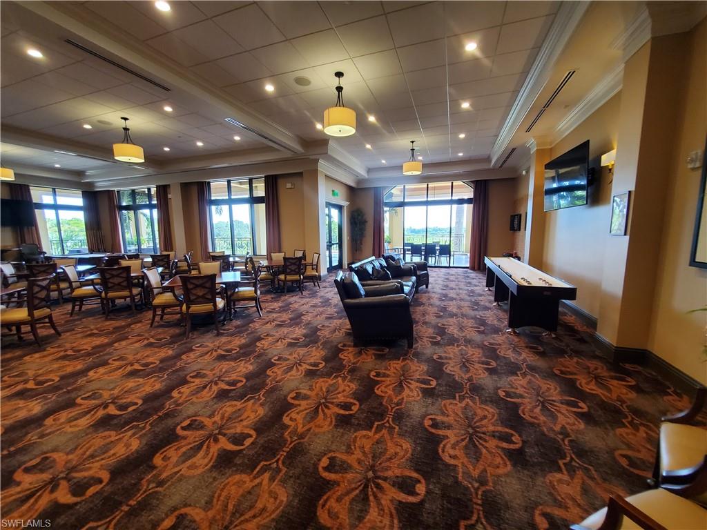 9596 Trevi Court, Unit 5428 Naples, FL 34113 - Photo 33 of 43 a living room with furniture a large window and chandelier