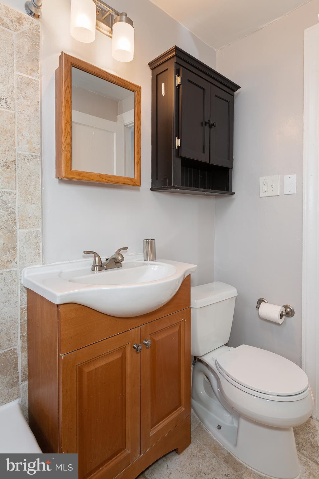2415 Ontario Road Northwest, Unit 101 Washington, DC 20009 - Photo 15 of 22 a bathroom with a toilet a sink and mirror