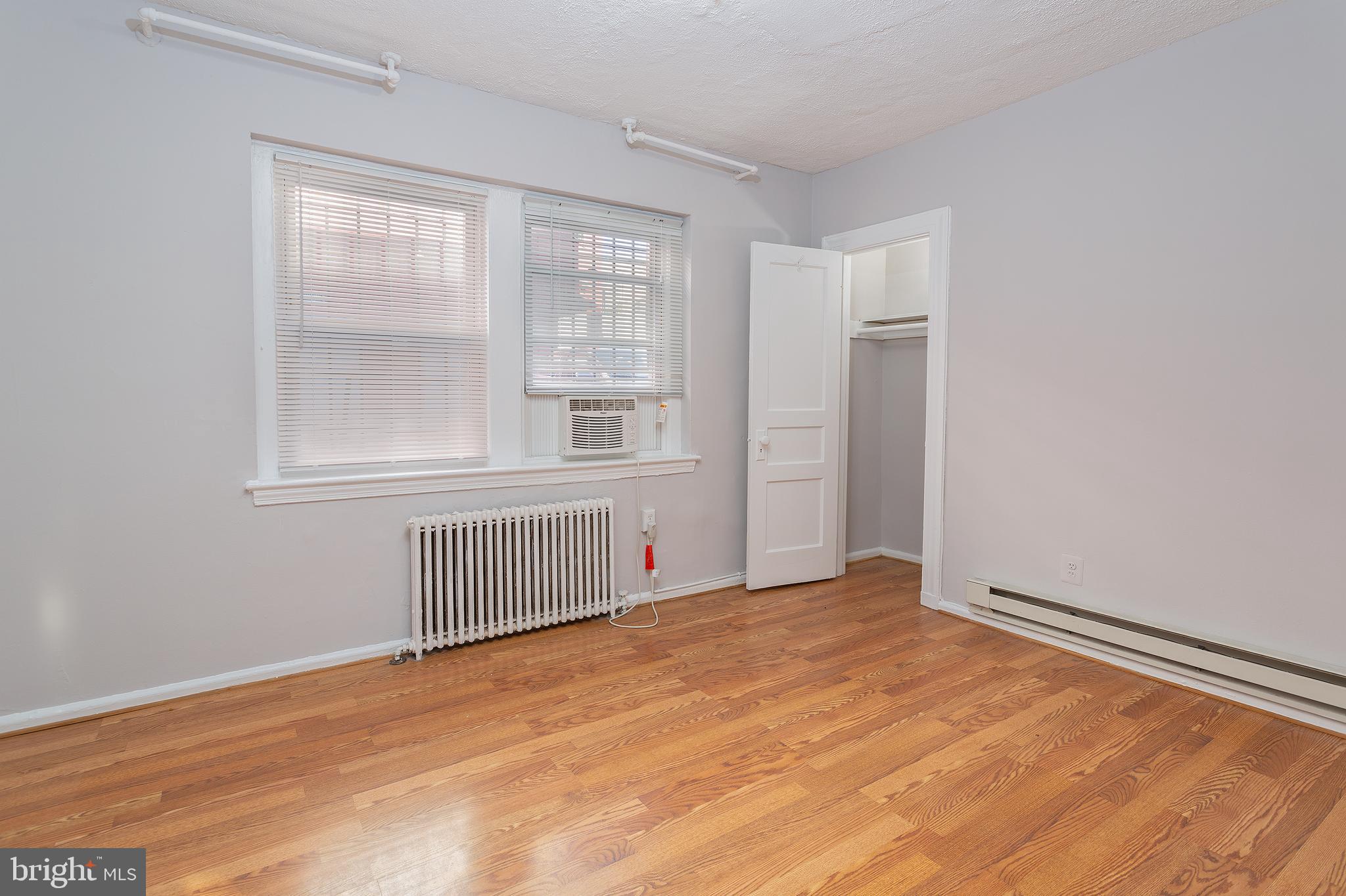 2415 Ontario Road Northwest, Unit 101 Washington, DC 20009 - Photo 17 of 22 an empty room with wooden floor and windows