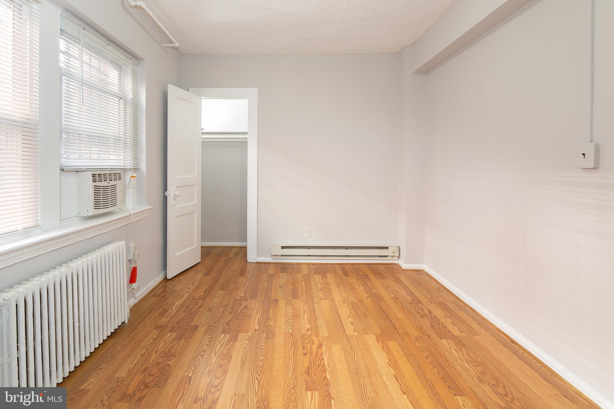 2415 Ontario Road Northwest, Unit 101 Washington, DC 20009 - Photo 20 of 22 a view of an empty room with wooden floor and a window
