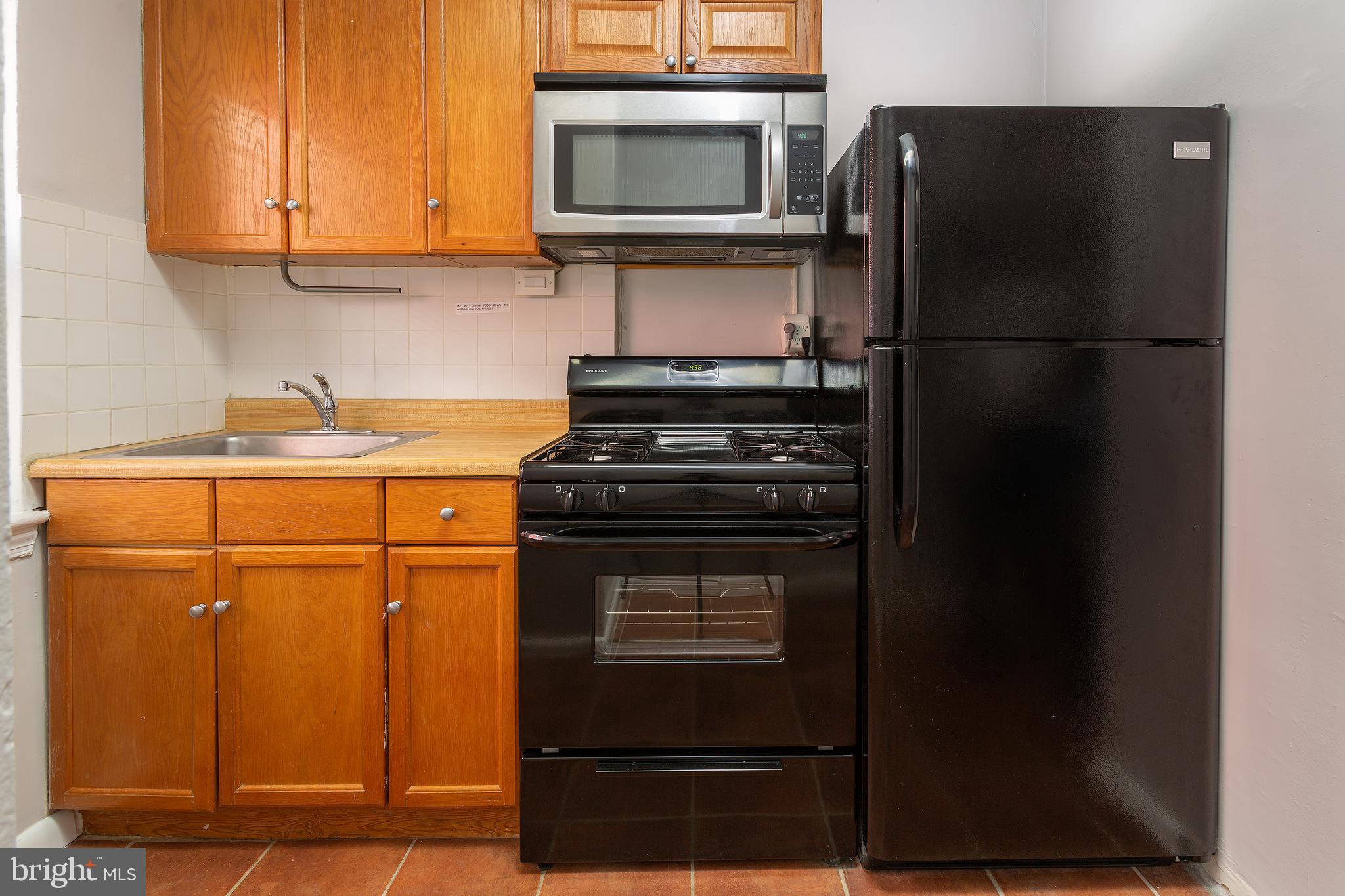 2415 Ontario Road Northwest, Unit 101 Washington, DC 20009 - Photo 7 of 22 a kitchen with a refrigerator and a stove