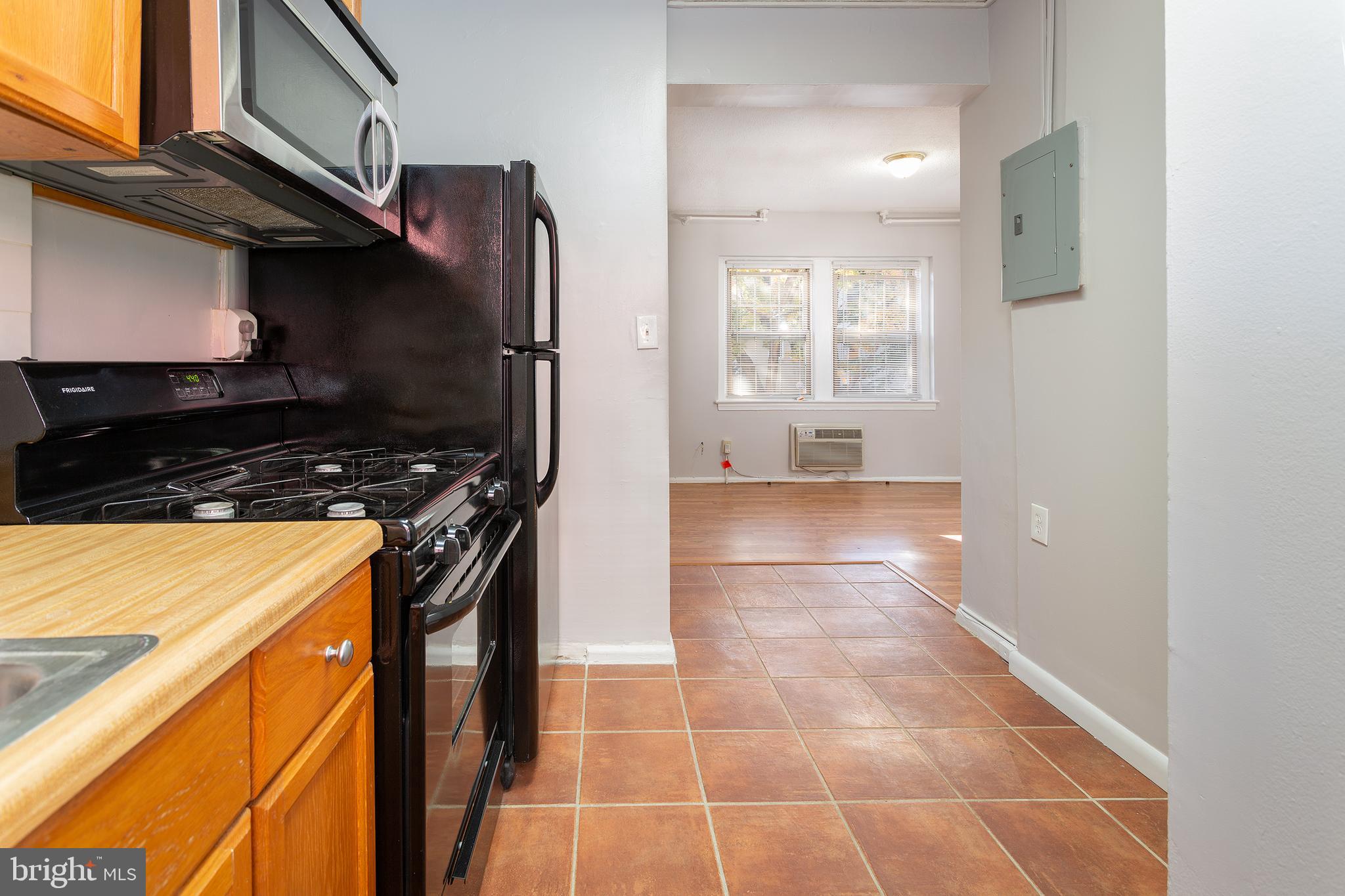 2415 Ontario Road Northwest, Unit 101 Washington, DC 20009 - Photo 8 of 22 a kitchen with granite countertop a stove a sink and a microwave