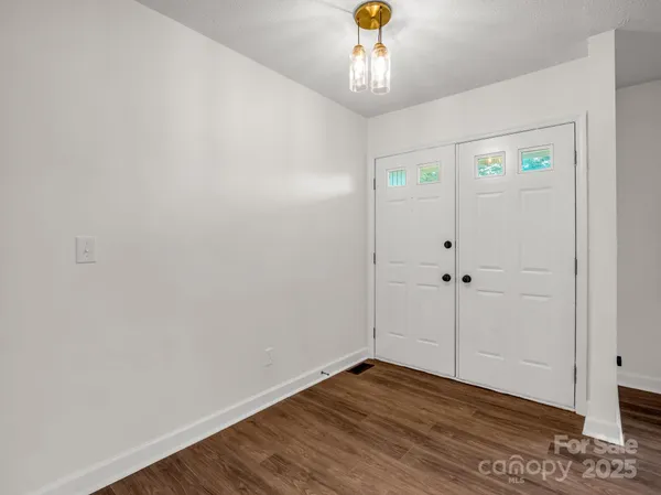 a large kitchen with stainless steel appliances kitchen island a large counter top a stove a chimney a sink and a refrigerator