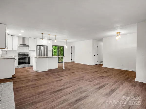 a view of a kitchen with a sink wooden floor and a window