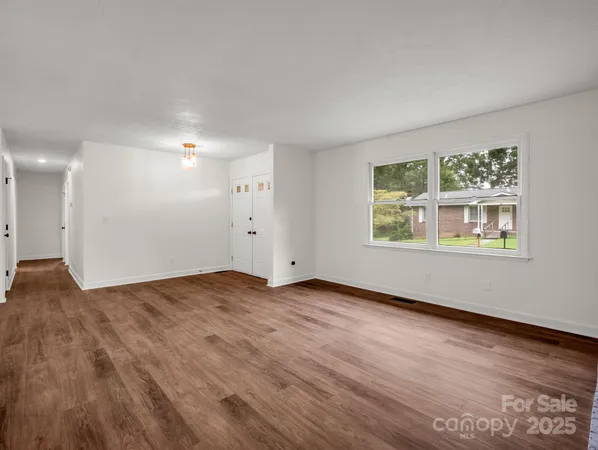 a view of an empty room with wooden floor