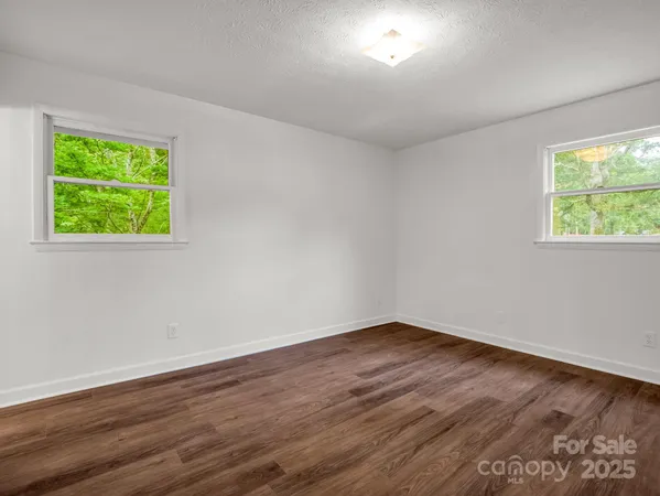 an empty room with wooden floor and fireplace