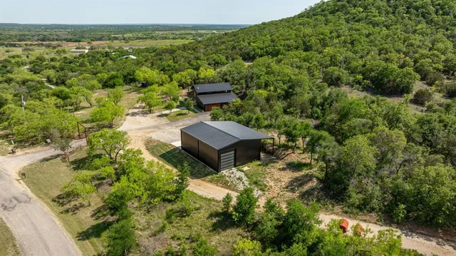 a view of a house with a yard and trees