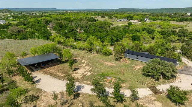an aerial view of residential houses with outdoor space and trees