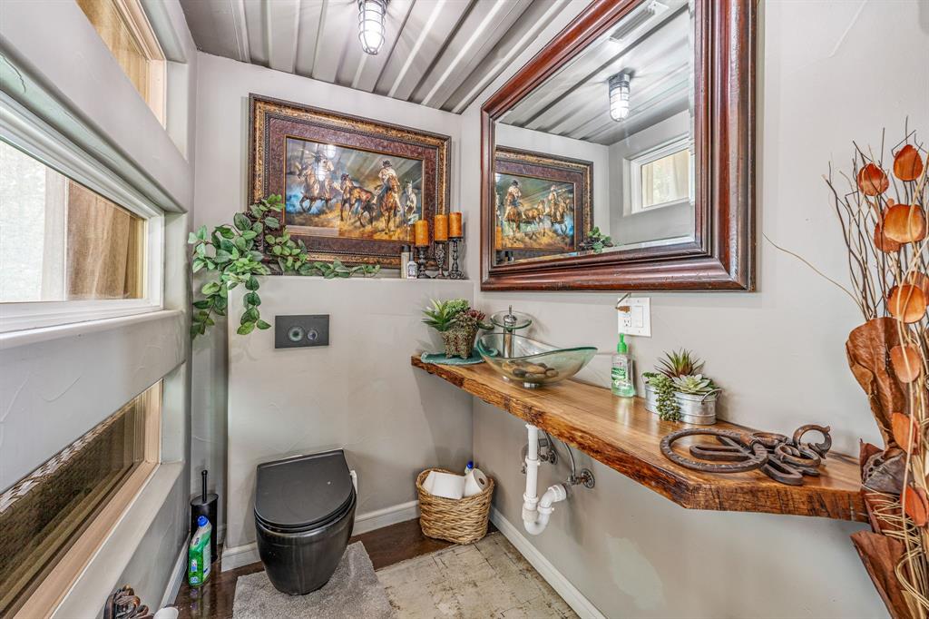886 Mitchell Hill Road Gordon, TX 76453 - Photo 10 of 34 a bathroom with a granite countertop sink a toilet and a window