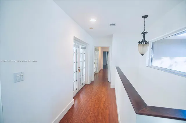 a view of a hallway with wooden floor and staircase