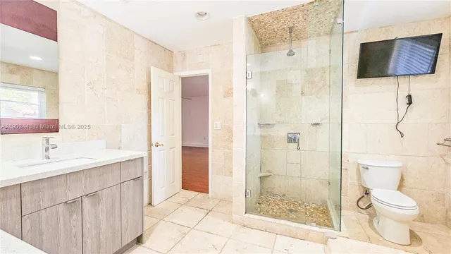 a bathroom with a granite countertop sink toilet and shower