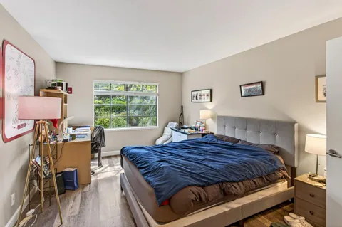 a bedroom with a bed and wooden floor