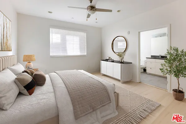 a bedroom with a bed mirror and window