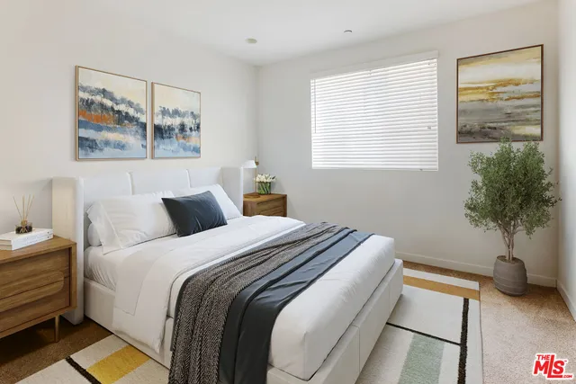 a bedroom with bed and a potted plant
