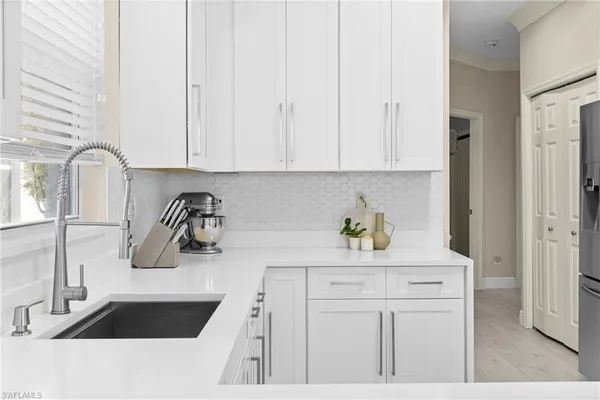 a kitchen with white cabinets and a sink