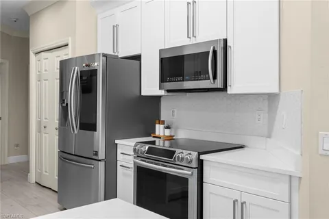 a kitchen with stainless steel appliances a refrigerator microwave and sink