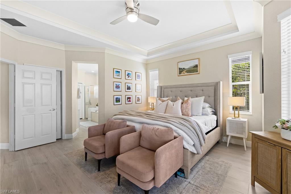 1869 Pondside Lane Naples, FL 34109 - Photo 19 of 34 Bedroom with light wood-type flooring, a ceiling fan, ensuite bathroom, a raised ceiling, and crown molding
