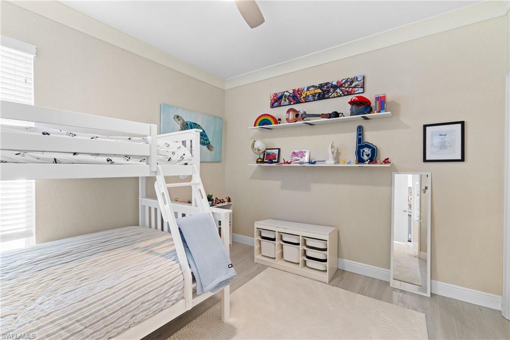 1869 Pondside Lane Naples, FL 34109 - Photo 22 of 34 Bedroom with light wood-style flooring, a ceiling fan, and crown molding