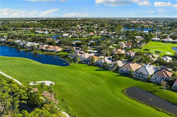 an aerial view of residential houses with outdoor space and trees