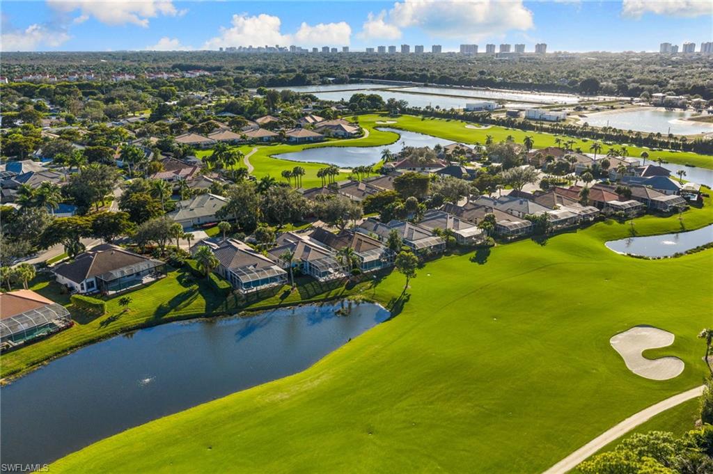 1869 Pondside Lane Naples, FL 34109 - Photo 32 of 34 Aerial perspective of suburban area with a large body of water, city skyline, and a local golf course