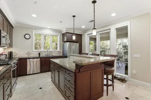 a kitchen with stainless steel appliances granite countertop a stove a sink island and a refrigerator