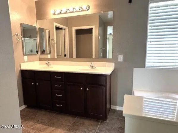 a view of a bathroom with water heater and wooden cabinets