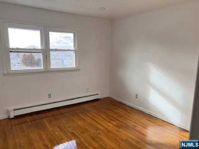 an empty room with wooden floor and closet