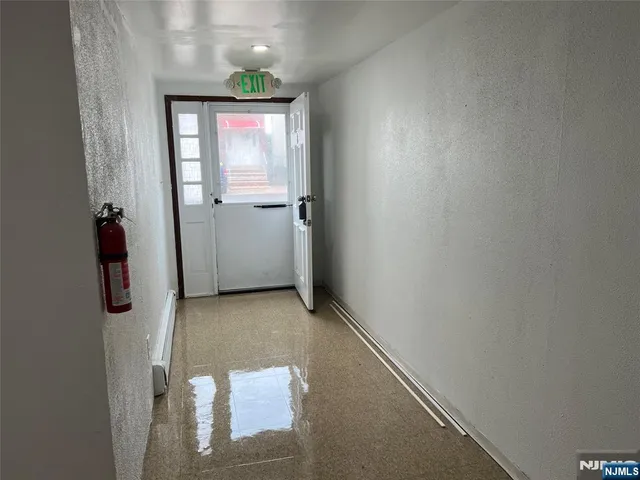 a view of an empty room with wooden floor and staircase