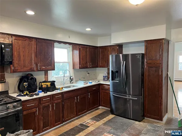 a kitchen with granite countertop a stove sink and cabinets