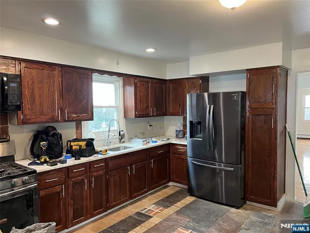 a kitchen with granite countertop a stove sink and cabinets