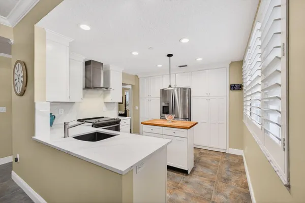 a kitchen with stainless steel appliances kitchen island granite countertop a sink a stove and a wooden floors