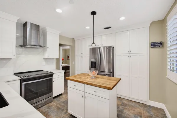 a kitchen that has a lot of cabinets in it and white appliances