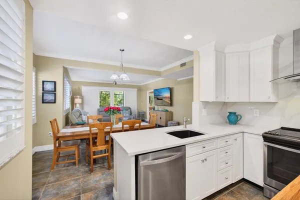 a kitchen that has a sink a stove and a table in it